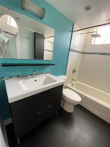 a bathroom with a sink vanity mirror and toilet