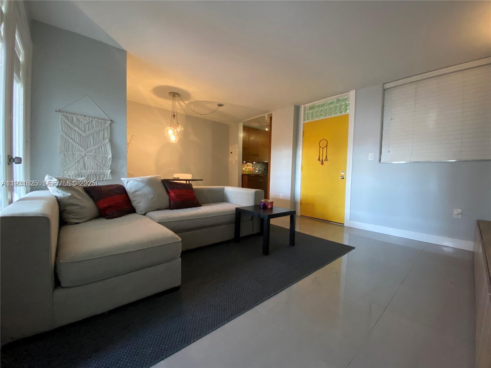 921 Jefferson Avenue, Unit 3B Miami Beach, FL 33139 - Photo 3 of 13 a living room with furniture and a lamp