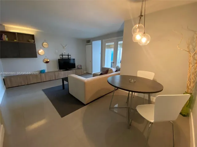 a living room with furniture a lamp and a flat screen tv