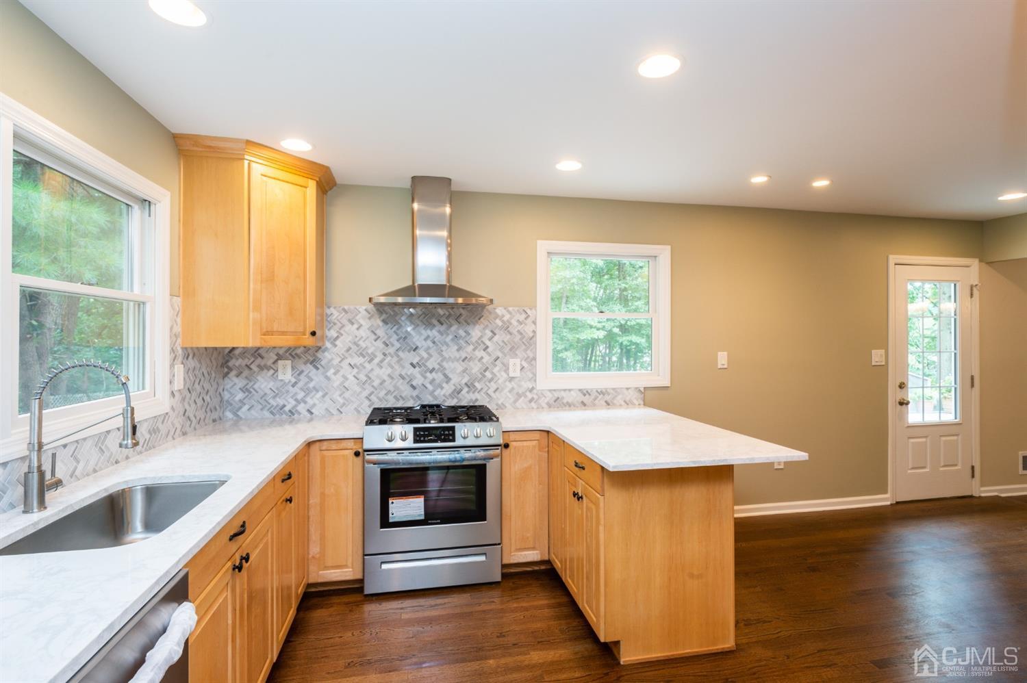 20 Donald Road East Brunswick, NJ 08816 - Photo 7 of 28 a kitchen with stainless steel appliances granite countertop a sink a stove and a wooden floors