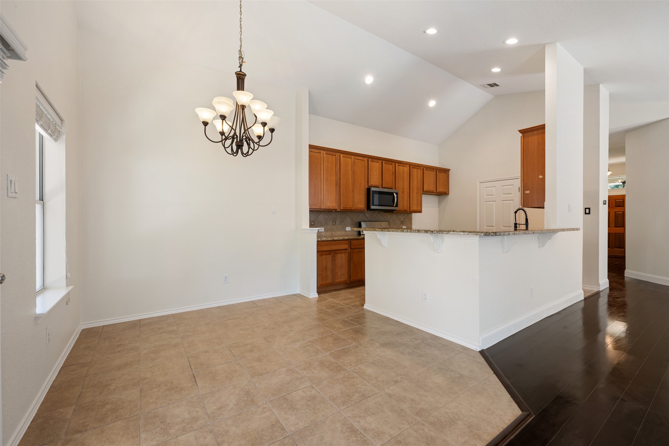 14316 Marathon Road Austin, TX 78717 - Photo 40 of 40 An open floor plan connects the tiled dining area to the kitchen under vaulted ceilings.