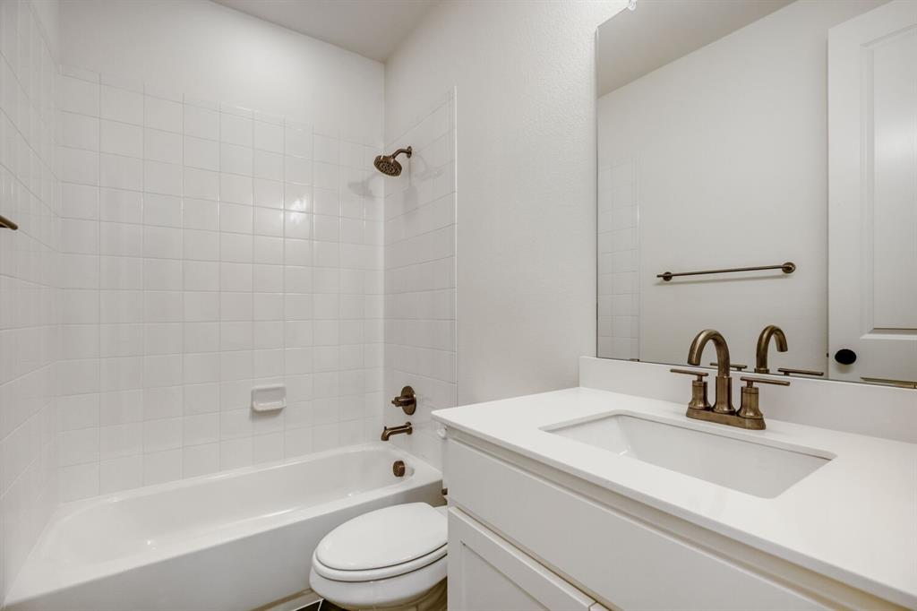 4314 Haley Way Oak Point, TX 75068 - Photo 19 of 28 Bathroom featuring a built-in tub with white subway tile surround, a white vanity with integrated sink, and an expansive wall-mounted mirror