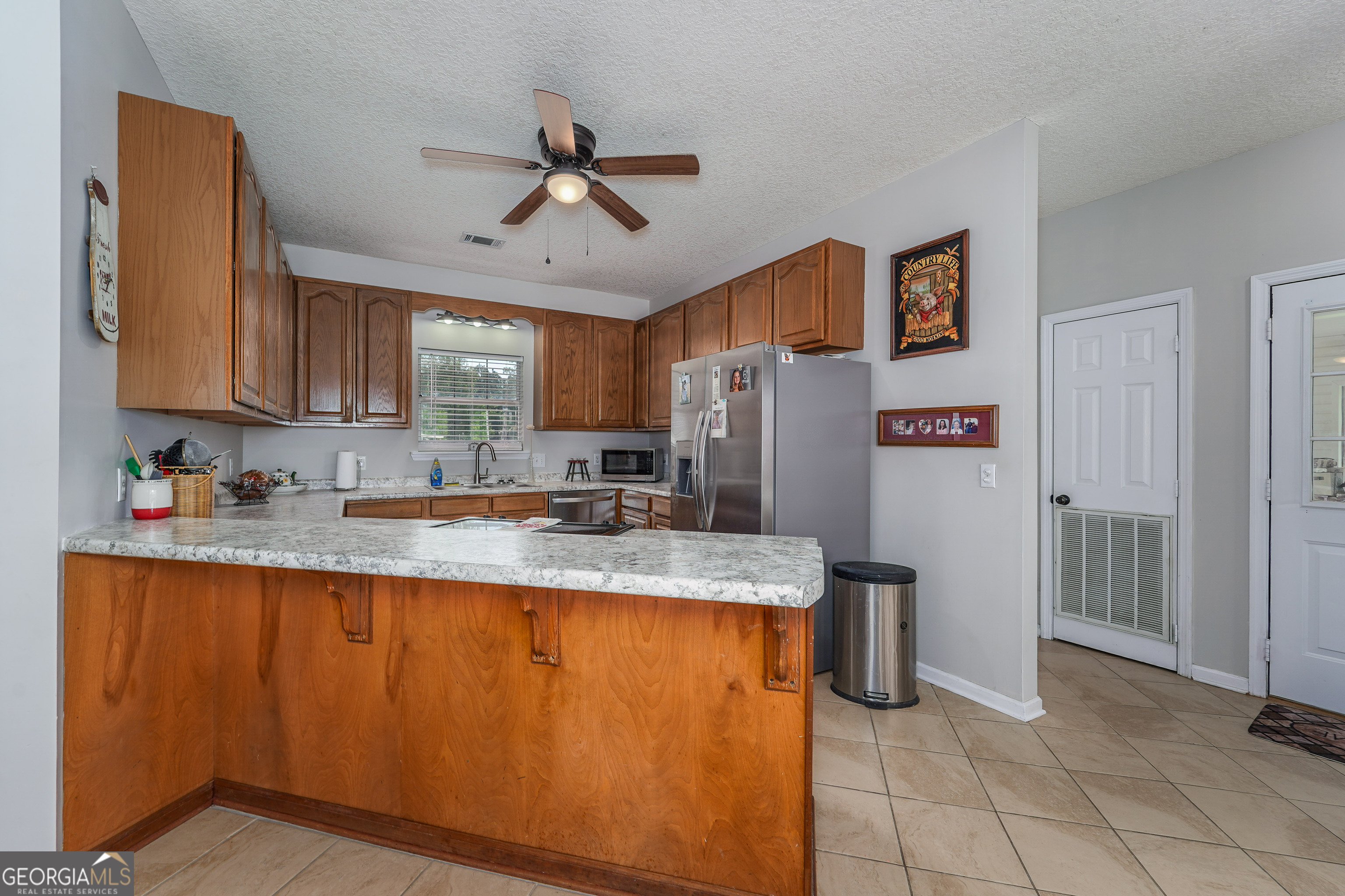 400 Smith Road Waycross, GA 31503 - Photo 11 of 25 a kitchen with stainless steel appliances granite countertop a sink refrigerator and cabinets