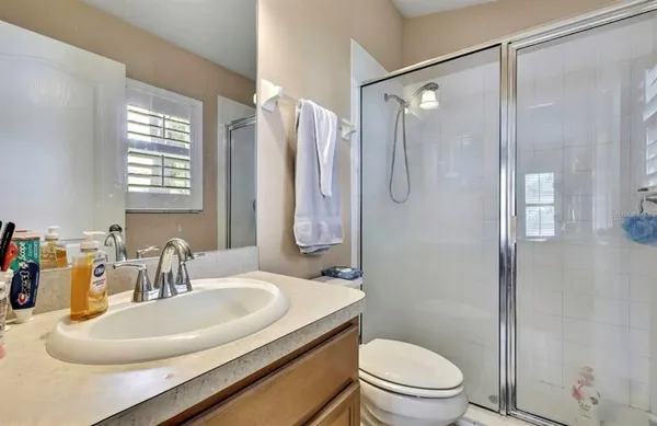 a bathroom with a sink toilet mirror and shower