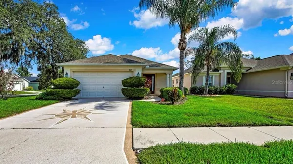 a front view of a house with a yard and potted plants