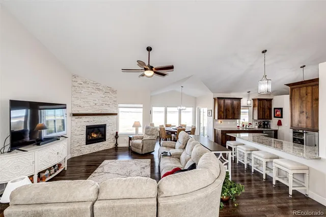 a view of a dining room and livingroom with furniture wooden floor a chandelier