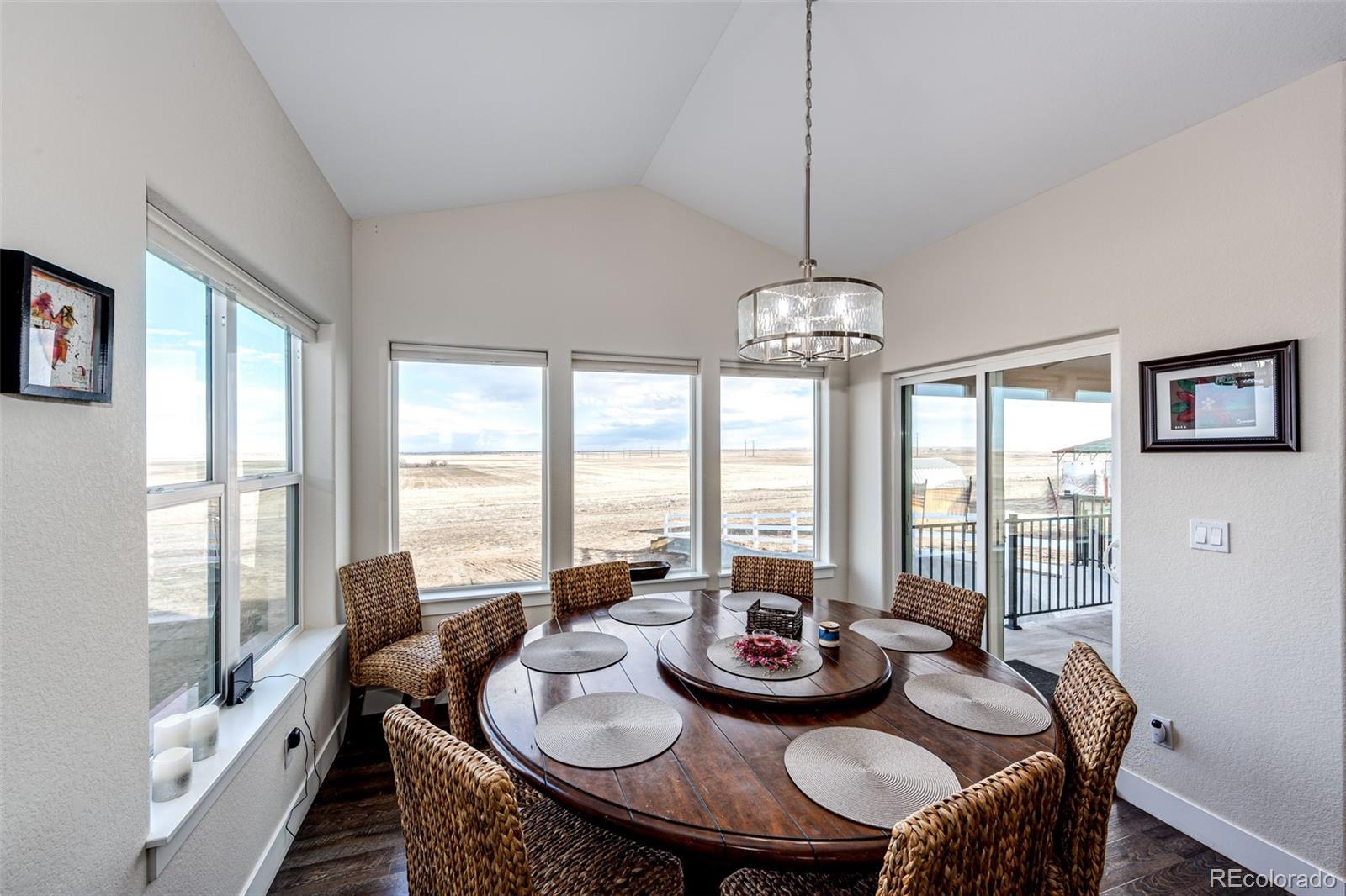 4820 Kiowa-Bennett Road Bennett, CO 80102 - Photo 13 of 29 a view of a dining room with furniture large windows and wooden floor