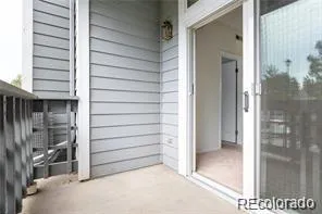 a view of a porch with a floor to ceiling window and wooden fence
