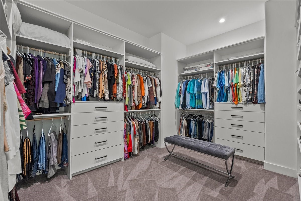 7627 Scott Avenue Manvel, TX 77578 - Photo 27 of 50 This expansive 14 x 11 primary walk-in closet features floor-to-ceiling custom built-ins, multiple drawer banks, and enough space for a center seating area.