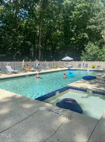 a view of yard with swimming pool and trees in the background