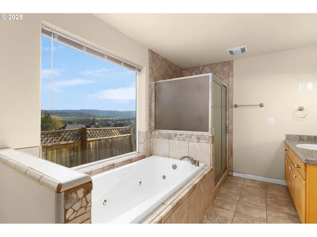 a bathroom with a tub a sink and a large window
