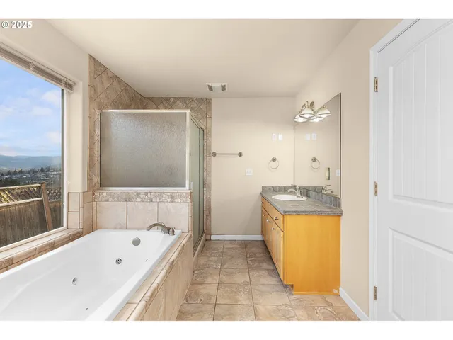 a bathroom with a tub a sink a mirror and a shower