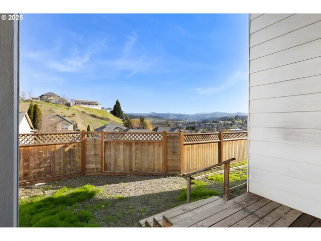 a view of a backyard with wooden fence