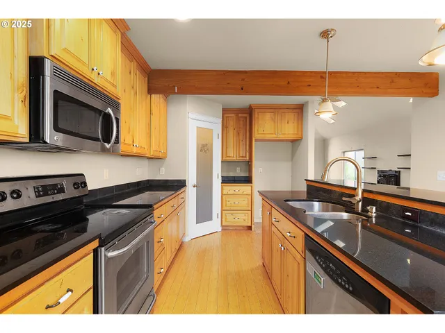 a kitchen with stainless steel appliances granite countertop a sink stove and microwave