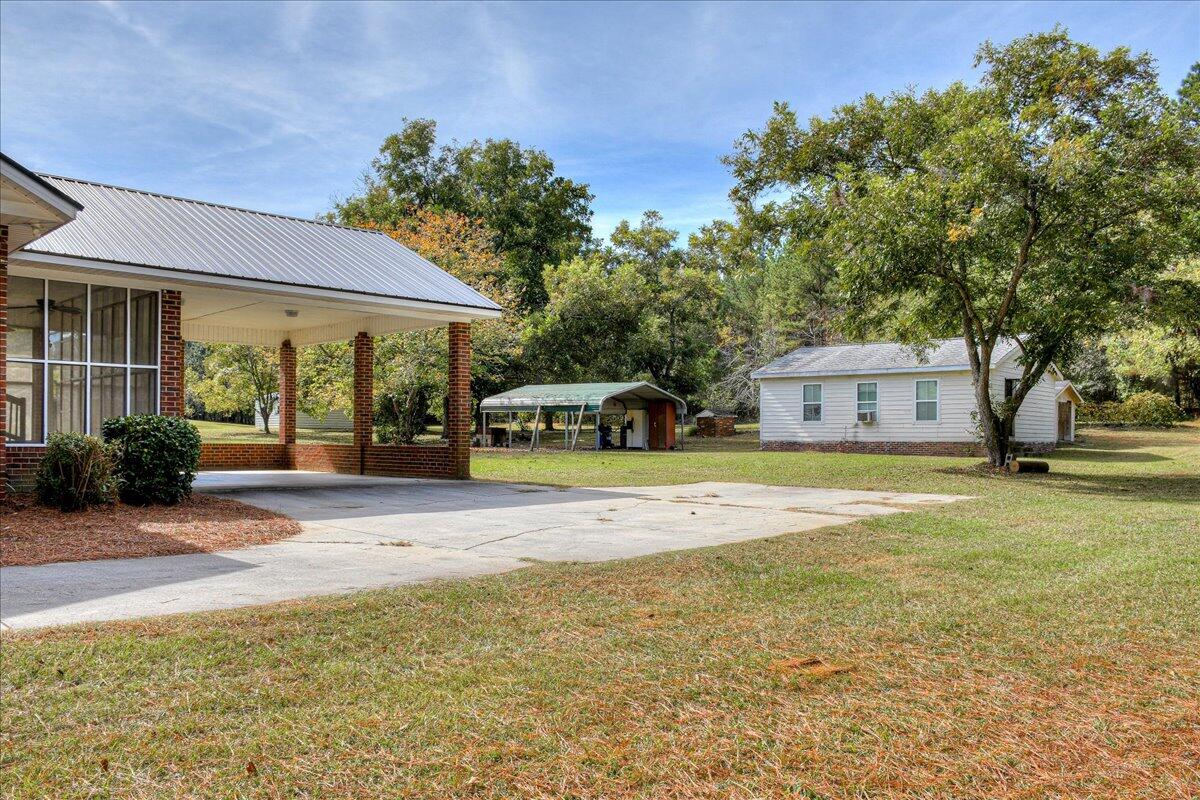 165 Morris Road Thomson, GA 30824 - Photo 3 of 26 This beautiful property features two carports (one attached and one detached), a workshop with power, water, and a bathroom, as well as a shed!