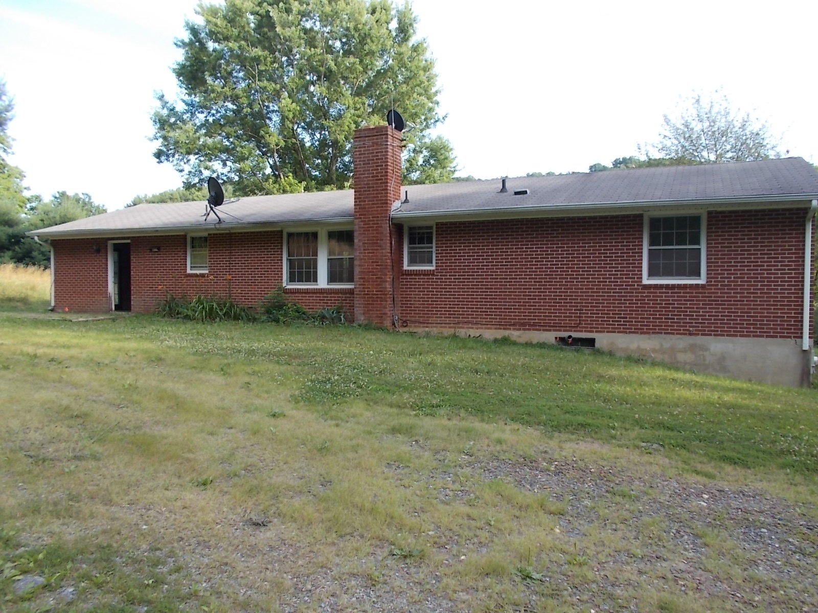 8974 Pine Forest Road Northeast Copper Hill, VA 24079 - Photo 7 of 21 a brick house with a yard and a large tree