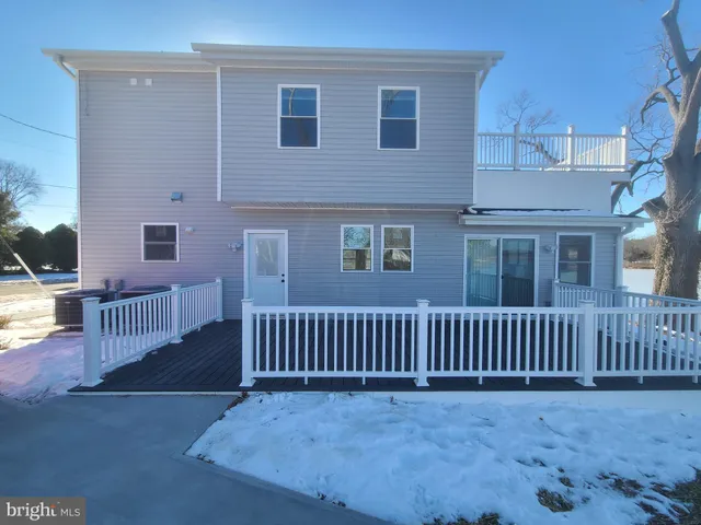 a view of a house with wooden fence and porch