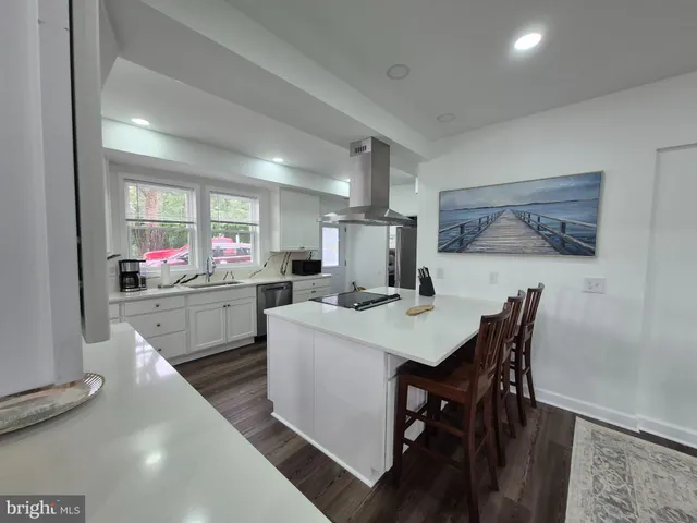 a kitchen with a dining table chairs and white cabinets