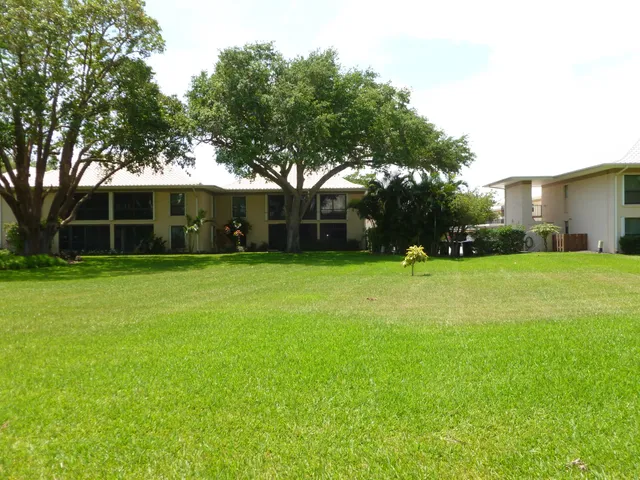 a view of house with a backyard