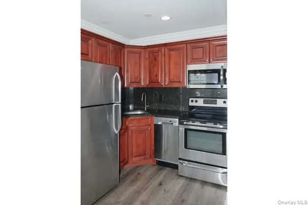a kitchen with stainless steel appliances granite countertop a refrigerator and a stove top oven