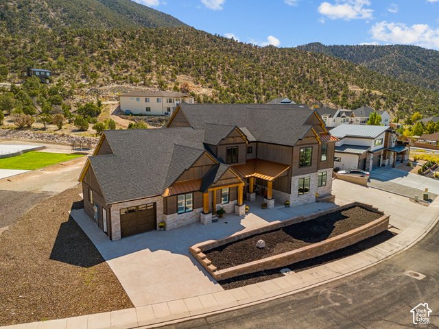 1192 East Ashdown Road Cedar City, UT 84721 - Photo 4 of 96 Multi-level exterior featuring stone and wood-look siding, attached two-car garage, covered entry with wood columns, and a terraced front planter