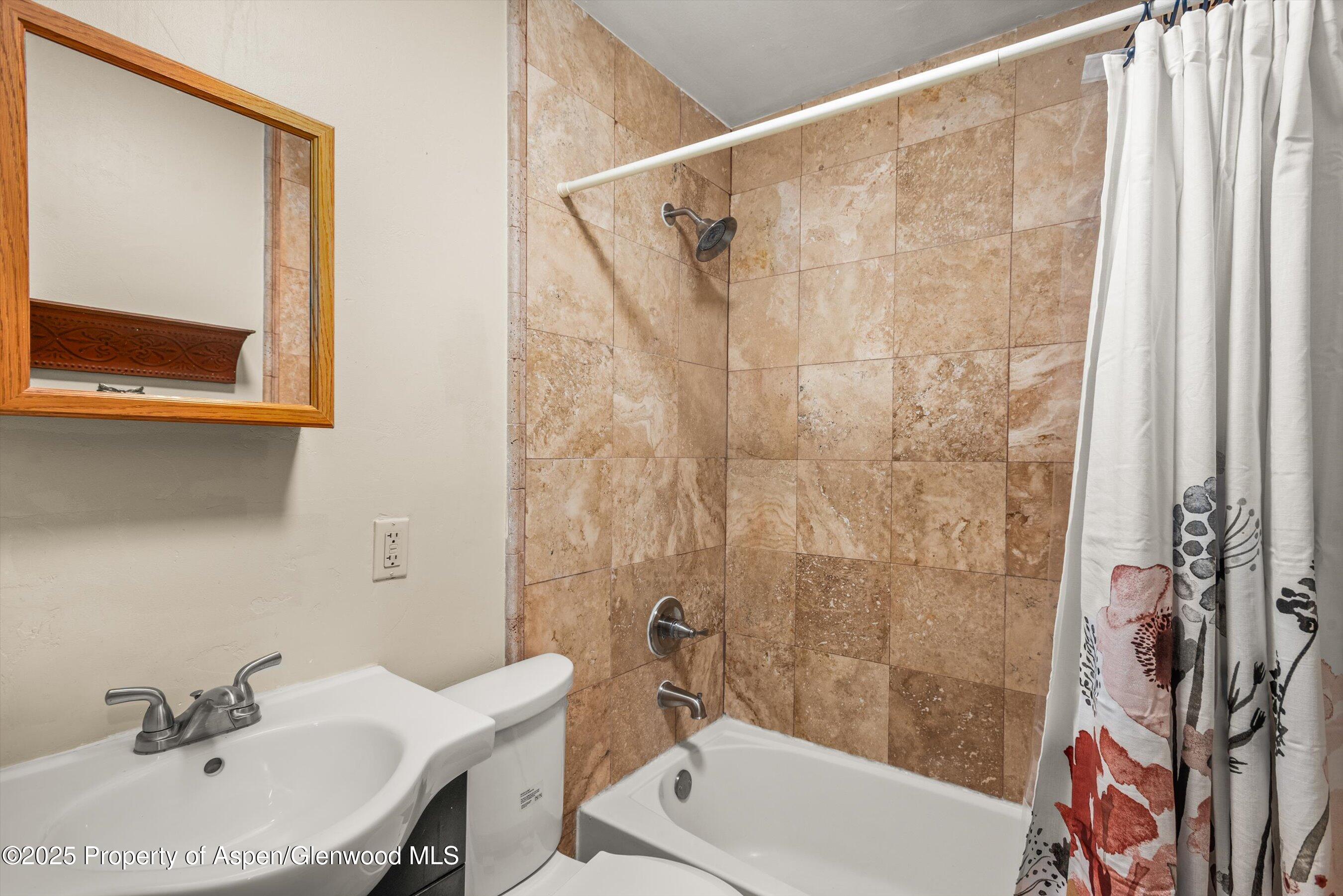 718 Main Street Carbondale, CO 81623 - Photo 11 of 27 a bathroom with a sink a mirror and a shower