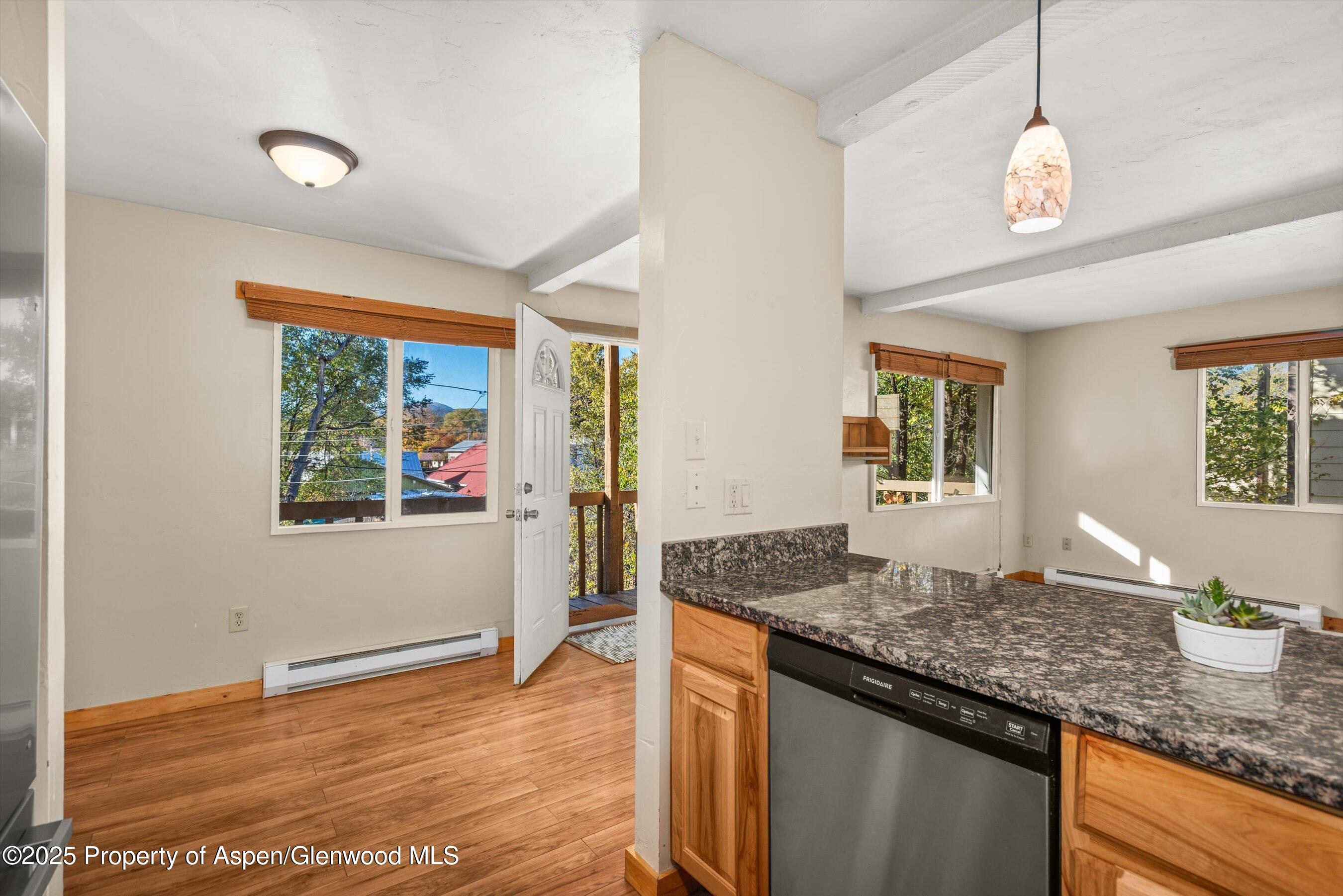 718 Main Street Carbondale, CO 81623 - Photo 5 of 27 a kitchen with granite countertop kitchen island a stove a sink and a wooden cabinets