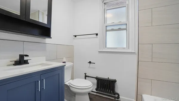 a bathroom with a sink toilet and mirror