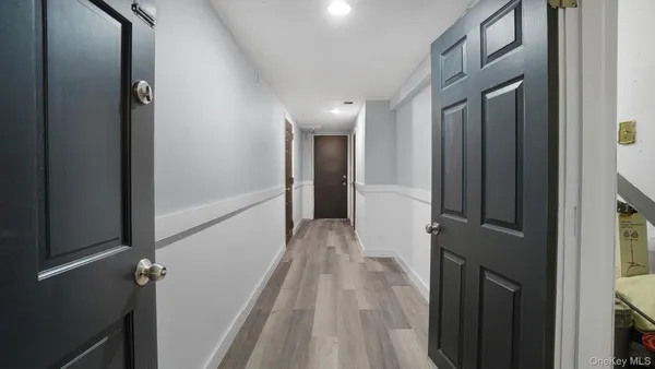 a view of a hallway with wooden floor and staircase