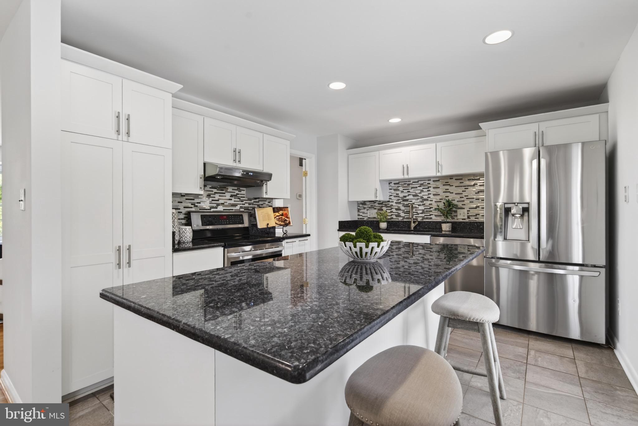 6535 Old Chesterbrook Road McLean, VA 22101 - Photo 16 of 50 a kitchen with stainless steel appliances granite countertop a sink refrigerator and microwave