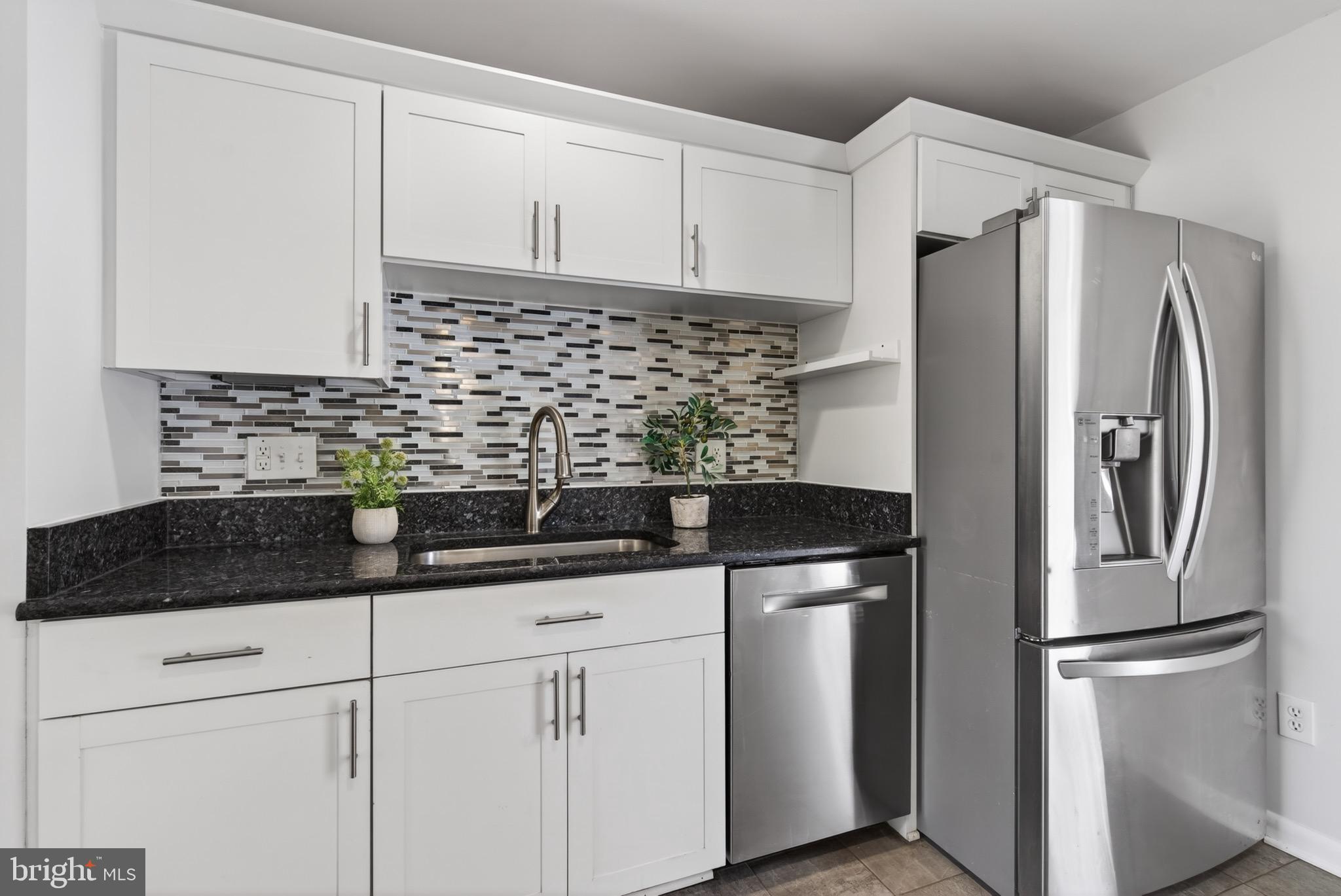6535 Old Chesterbrook Road McLean, VA 22101 - Photo 18 of 50 a kitchen with stainless steel appliances granite countertop a refrigerator a sink and white cabinets