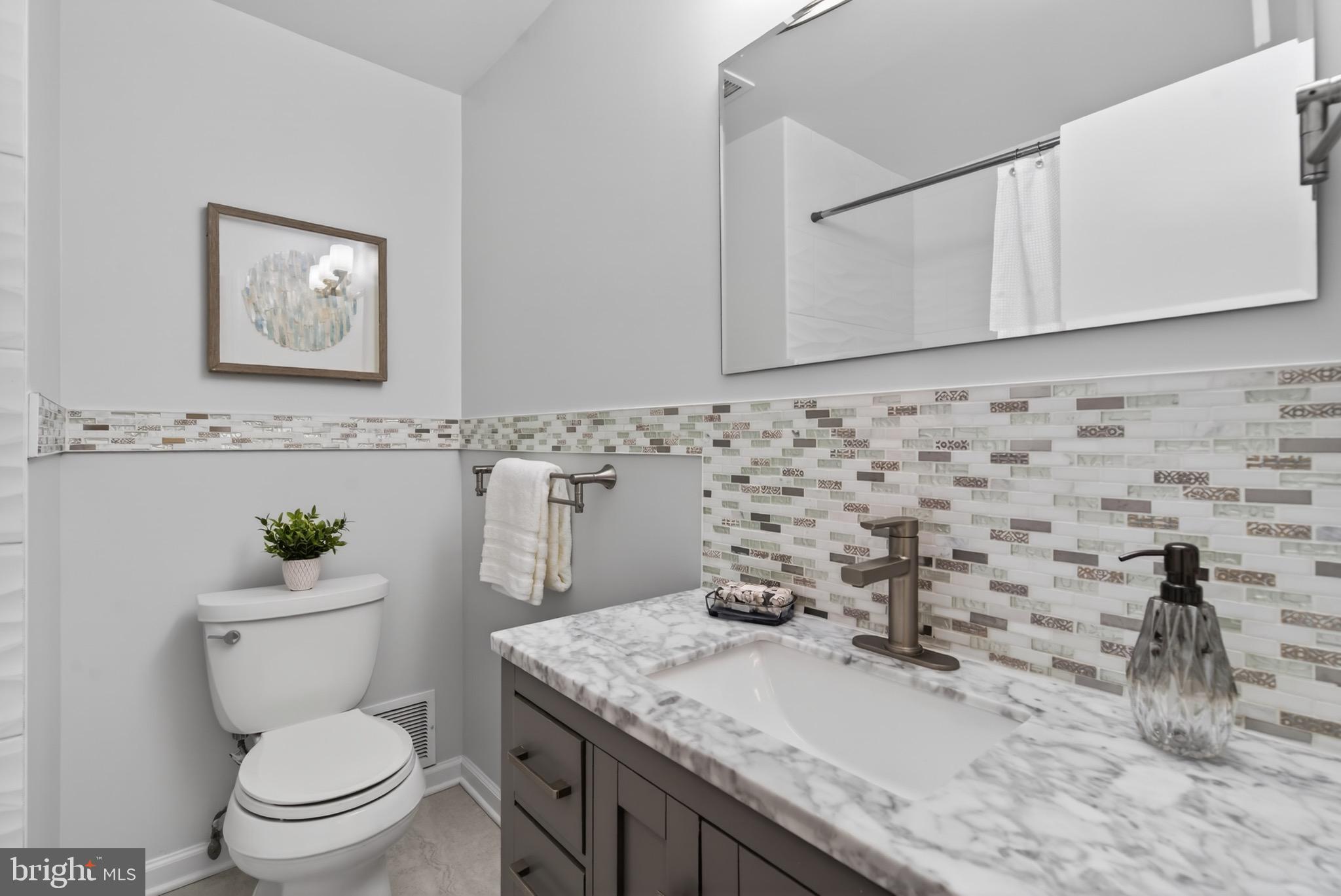 6535 Old Chesterbrook Road McLean, VA 22101 - Photo 31 of 50 a bathroom with a granite countertop toilet sink and mirror