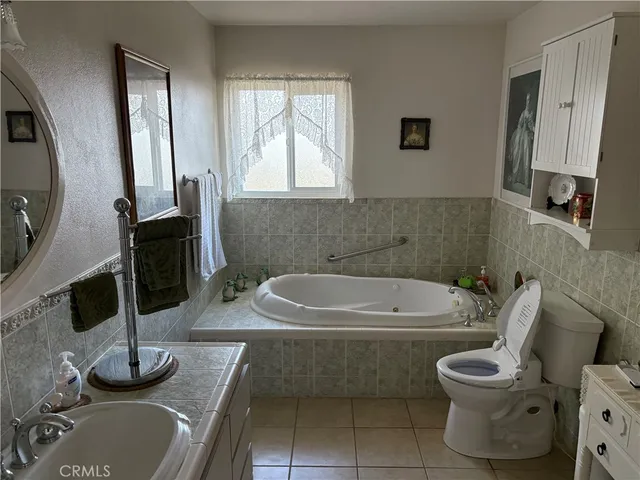 a bathroom with a granite countertop bathtub sink and toilet