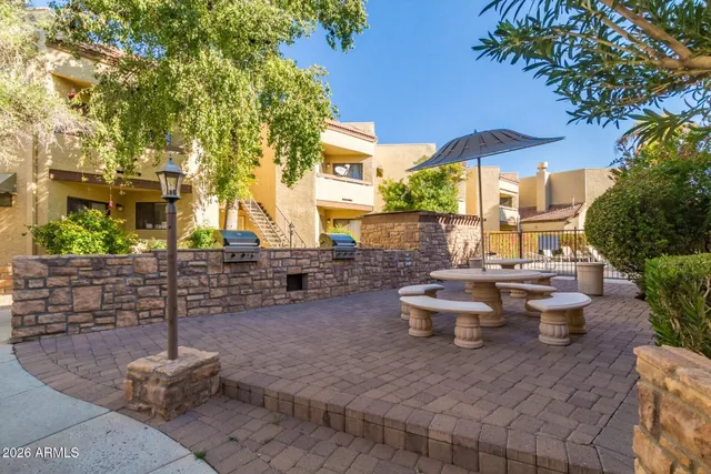 a view of a patio with table and chairs potted plants and a large tree
