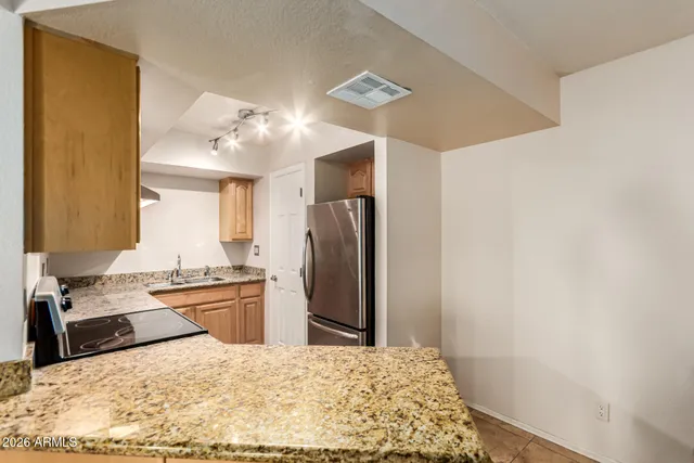 a kitchen with stainless steel appliances granite countertop a refrigerator sink and stove