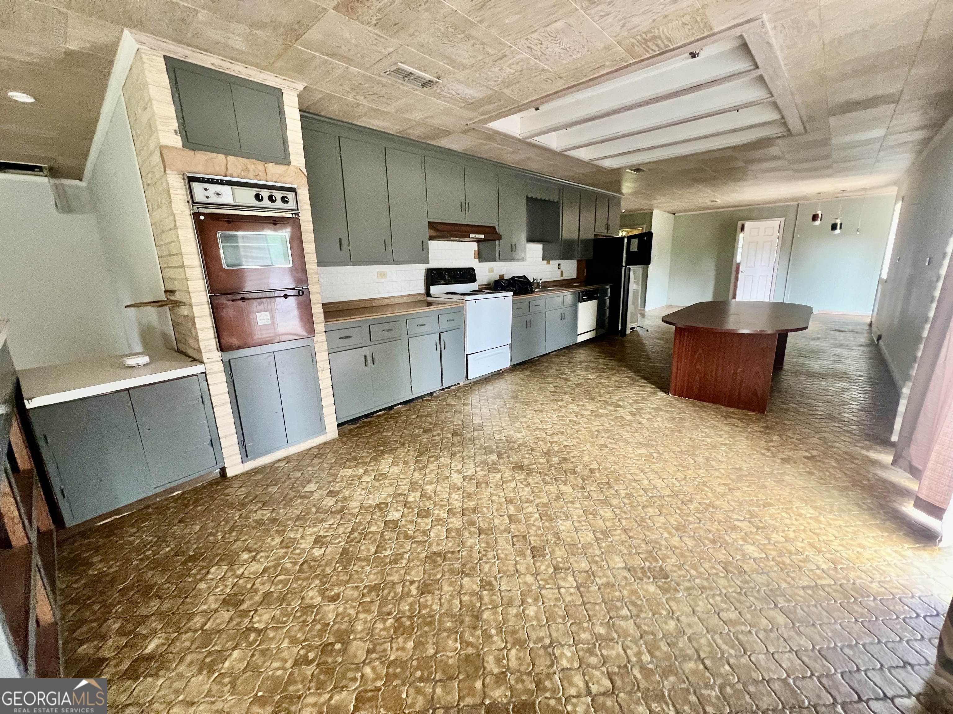 1165 Jaybird Springs Road Chauncey, GA 31011 - Photo 11 of 43 a kitchen with refrigerator cabinets and wooden floor