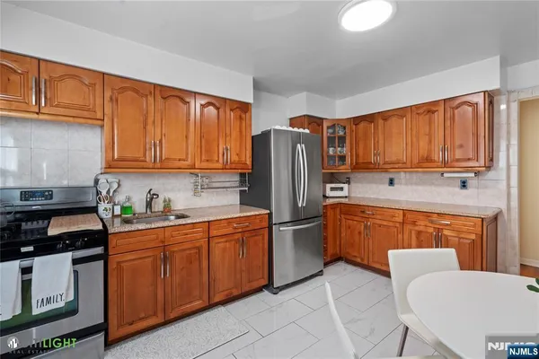 a kitchen with stainless steel appliances granite countertop a refrigerator stove top oven and sink