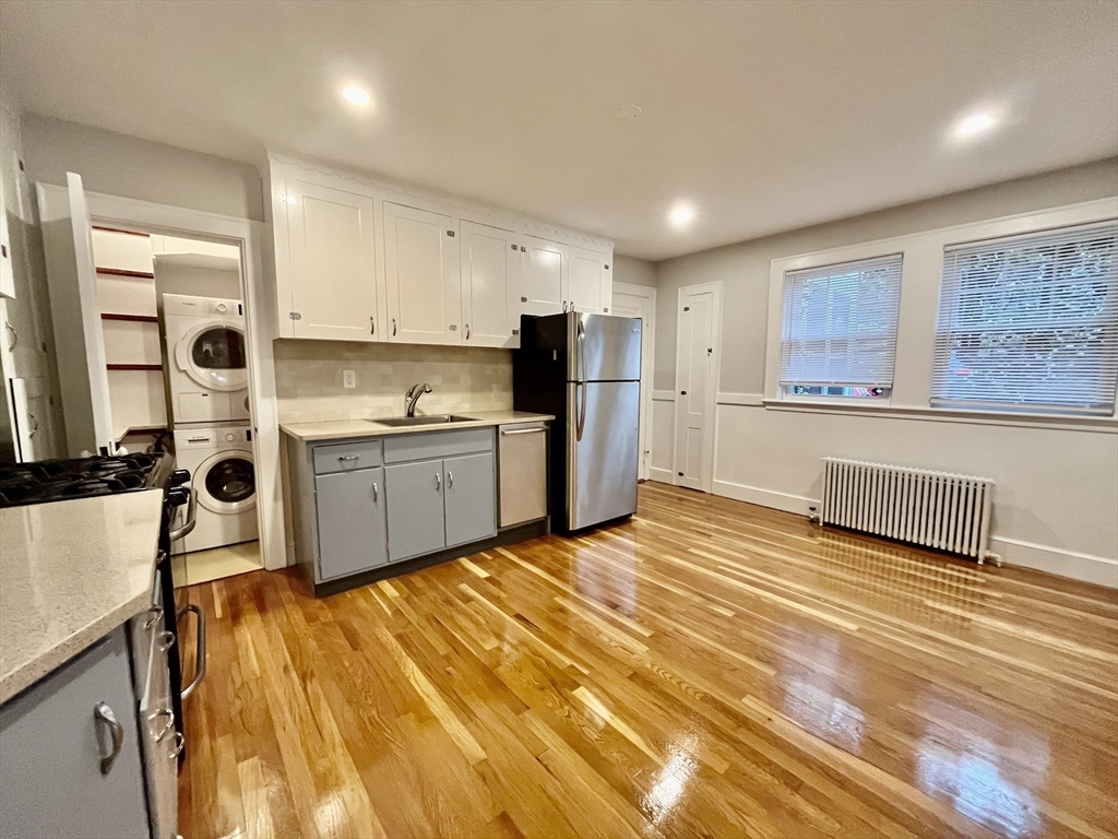 a large kitchen with stainless steel appliances a large counter top a stove and a refrigerator