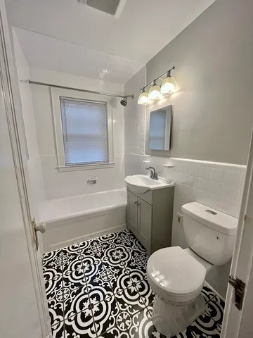 a bathroom with a sink toilet and mirror