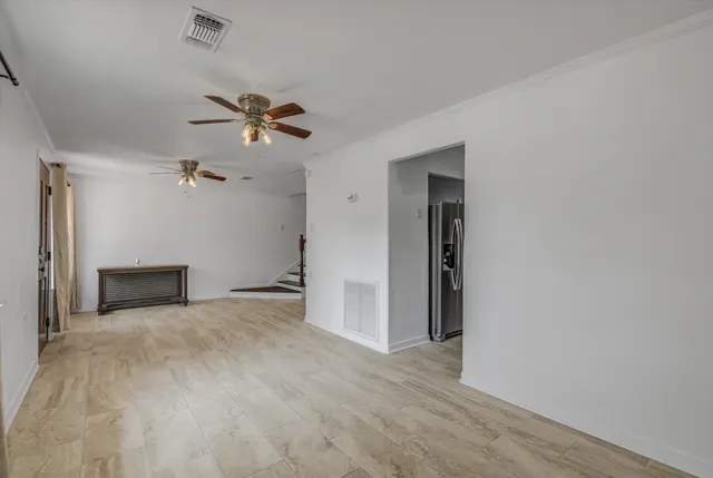 a view of an empty room with a ceiling fan