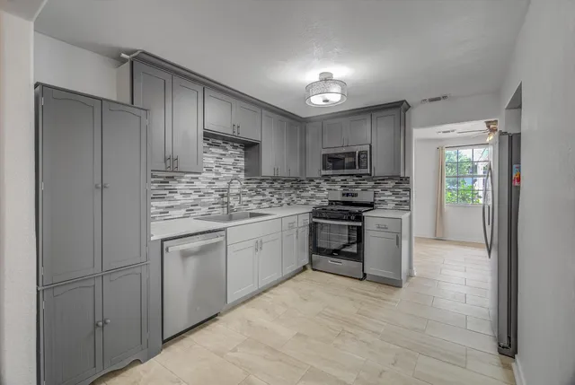 a view of a dining room with furniture and a chandelier fan
