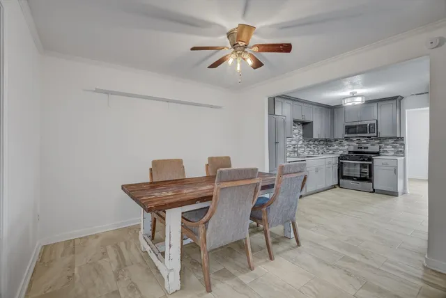 a view of a dining room with furniture and a chandelier fan