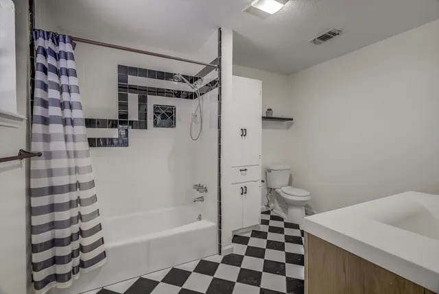 a bathroom with a sink a toilet a mirror and shower