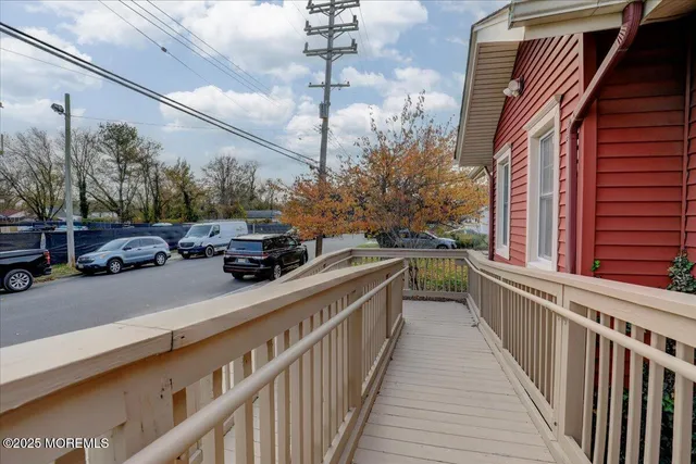 a view of a balcony and car parked side of road