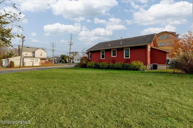 a view of a house with a big yard and large trees