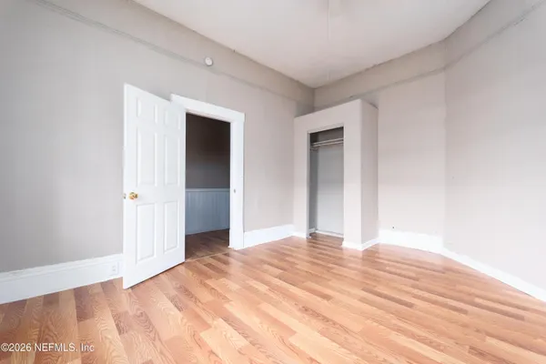 a view of an empty room with wooden floor