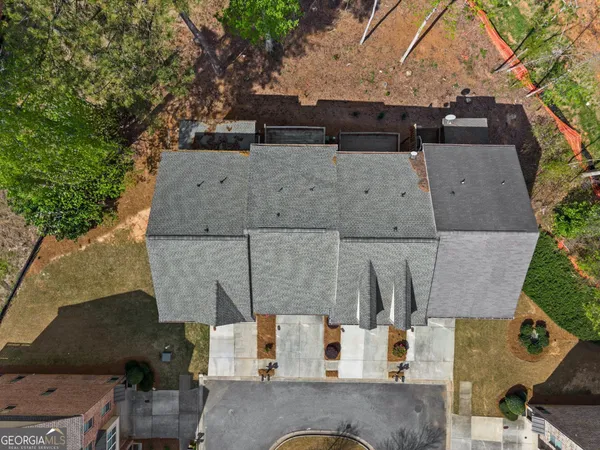 a view of a brick house with large windows and a table and chairs