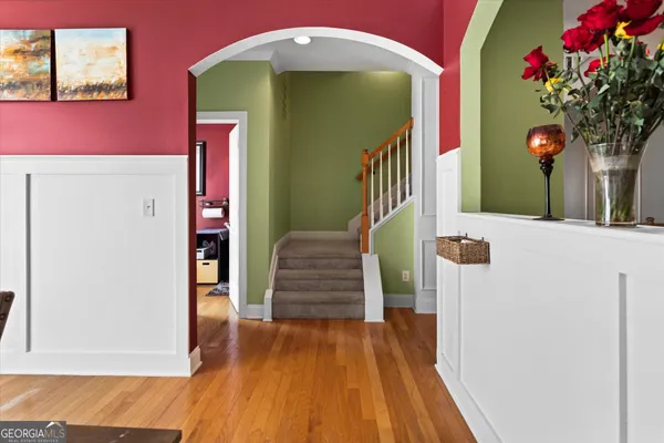 a kitchen with stainless steel appliances a refrigerator a stove a sink dishwasher and a chair with wooden floor