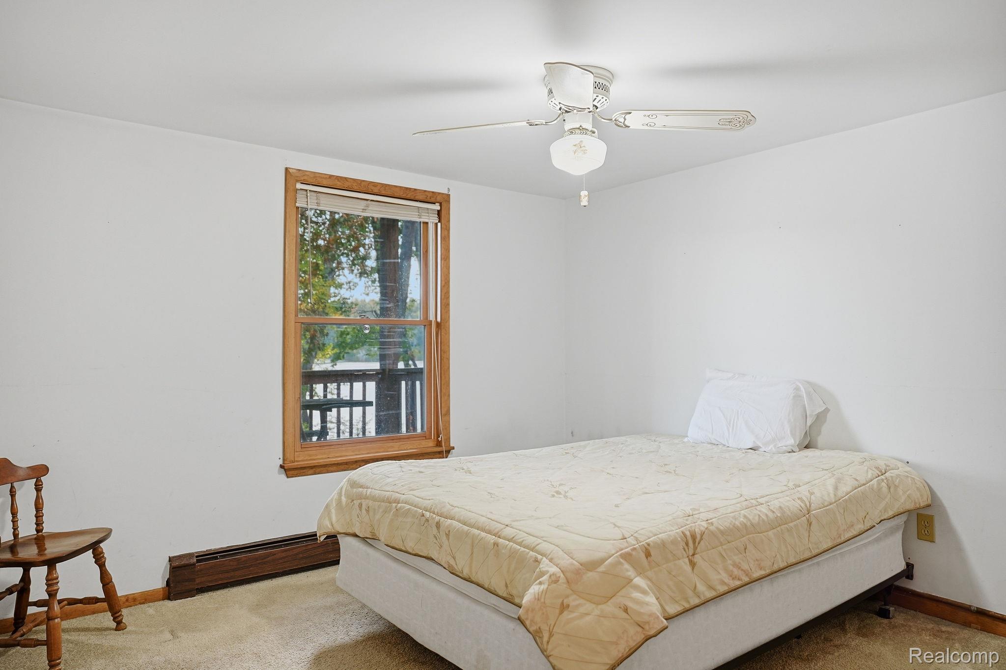 2259 Kassuba Road Gaylord, MI 49735 - Photo 28 of 46 White walls, wood-trimmed window, window blind, ceiling fan with light, and carpeted flooring