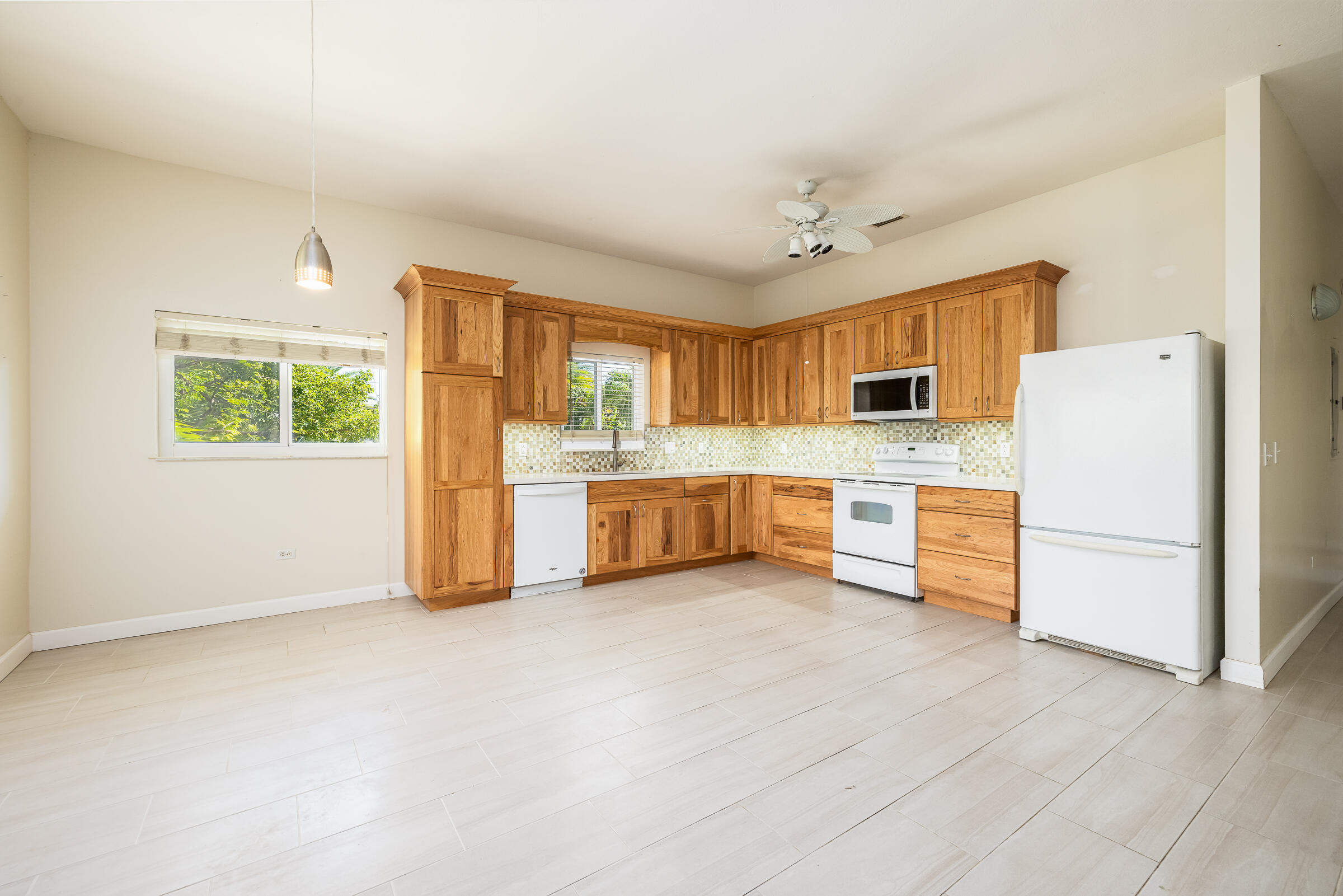 132 Galleon Road Islamorada, FL 33036 - Photo 13 of 38 a large white kitchen with a refrigerator a stove a microwave and a window